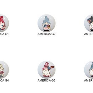 May include: Six round ceramic ornaments featuring gnomes in various patriotic poses. Each gnome is wearing a red, white, and blue hat and holding a patriotic symbol, such as a flag, a heart, or a watermelon. The ornaments are labeled "America G1" through "America G6".