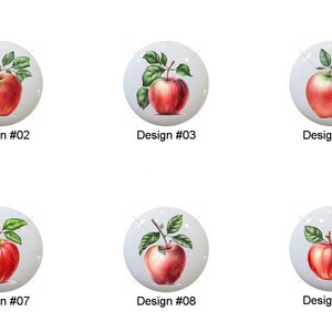 May include: A collection of ten white ceramic knobs, each featuring a watercolor painting of a red apple with green leaves. Each knob is labeled with a design number from #01 to #10.