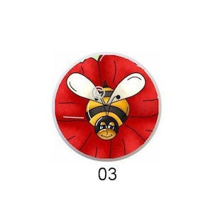 May include: A collection of five round decorative buttons. Each button features a different design, including smiling bees, a bee with a red background, and a bear with hearts. The buttons are numbered 01 through 05.