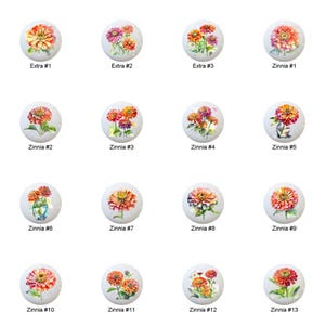 May include: A collection of decorative cabinet knobs featuring floral designs. Each knob showcases a different arrangement of zinnias in various colors, including orange, pink, and red, set against a white background. The knobs are labeled with text.