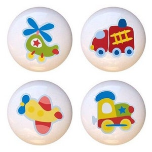 May include: Set of four ceramic knobs featuring colorful illustrations of a helicopter, fire truck, airplane, and train. Each knob is white with a blue, red, yellow, and green design.