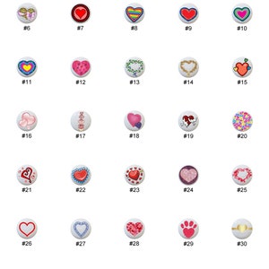 May include: Thirty ceramic heart-shaped buttons with various designs, including hearts, flowers, butterflies, and other patterns. The buttons are white with colorful designs.