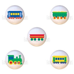 May include: Five white cabinet knobs with colorful train car designs. Each knob features a different train car in blue, green, yellow, and red, with yellow, red, and green accents. The text "FARM FRESH KNOBS" is printed on each knob.