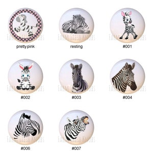 May include: Set of 7 ceramic cabinet knobs featuring different zebra designs. The knobs are white with black stripes and feature various poses, including a zebra resting, a zebra with its head turned, and a zebra with its mouth open. The knobs are labeled with numbers 001 through 007.