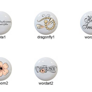 May include: Set of 10 ceramic knobs with various designs, including a pink blossom, a dragonfly, a quote about spring, and the words "Hidden Treasures" and "Cherry Blossom".