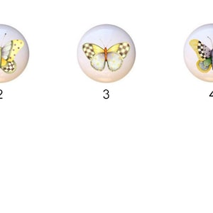 May include: Six ceramic knobs with different butterfly designs. Each knob is white with a yellow, green, and black butterfly.