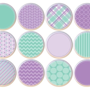 May include: Twelve round, white labels with different patterns in shades of purple and green. The patterns include polka dots, stripes, plaid, zigzags, and solid colors.