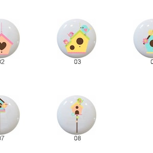 May include: Eight different ceramic knobs with birdhouse designs. Each knob features a different color scheme and birdhouse design. The knobs are numbered 1 through 8.