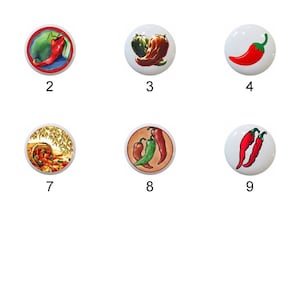 May include: Eleven ceramic knobs with different chili pepper designs. The knobs are white with red, green, and yellow chili peppers. The knobs are numbered 1 through 11.