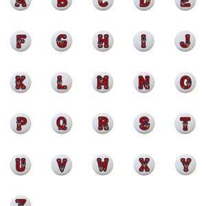 May include: A set of 26 alphabet letter buttons with a red, white, and blue American flag design. The letters are in uppercase and are arranged in alphabetical order.