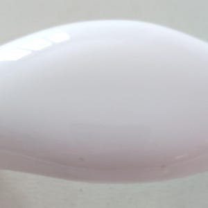 May include: A white, glossy, curved cabinet pull with rounded ends. The hardware has a smooth, reflective surface and a minimalist design. The pull is designed for easy gripping and opening of drawers or cabinets.