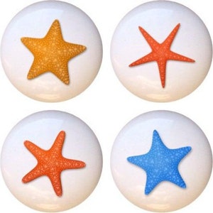 May include: Eight ceramic knobs with a white background and a starfish design. The starfish are in four different colors: blue, orange, yellow, and red.