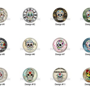 May include: A collection of twelve round decorative cabochons featuring colorful sugar skull designs. Each cabochon has a different skull design with various patterns and colors, including floral and clock faces. The designs are labeled with numbers.