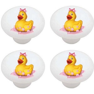 May include: Four white ceramic knobs with a pink and yellow rubber ducky in a bubble bath design.