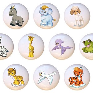 May include: A collection of ten white ceramic cabinet knobs, each featuring a different cartoon animal illustration. Animals include a donkey, elephant, lamb, zebra, giraffe, bird, frog, leopard, dove, and tiger. These knobs are perfect for a child's room or nursery.