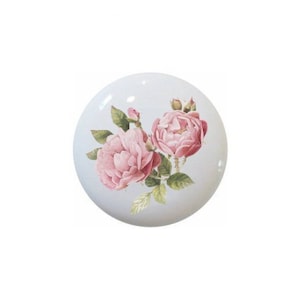 May include: A ceramic knob with a floral design featuring two pink roses with green leaves on a white background.