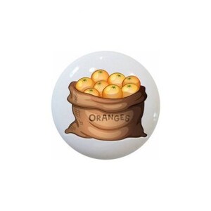 May include: Three ceramic knobs with illustrations of burlap sacks filled with produce. The first knob has a sack of onions, the second has a sack of oranges, and the third has a sack of potatoes.