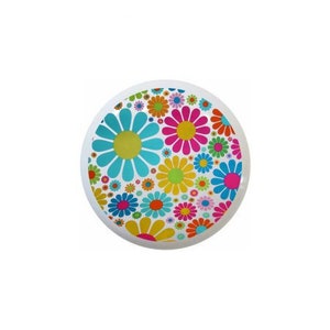 May include: A white round disc with a colorful pattern of blue, pink, yellow, and green flowers.