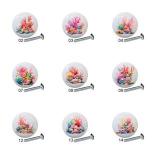 May include: Fifteen ceramic cabinet knobs with colorful coral reef designs. Each knob is white with a different coral reef scene featuring pink, orange, yellow, and blue colors.