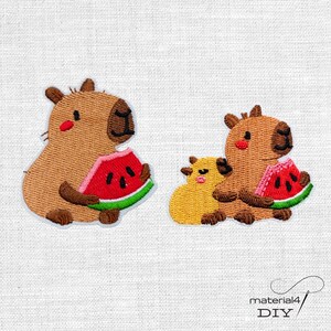 Könnte beinhalten: Zwei gestickte Aufnäher mit braunen Wasserschweinen, die rote Wassermelonenstücke mit grüner Schale und schwarzen Kernen essen. Ein Aufnäher zeigt ein einzelnes Wasserschwein, der andere ein Wasserschwein mit einem kleinen gelben Tier daneben.