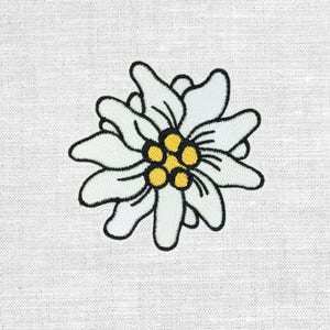 Könnte beinhalten: Gestickte weiße Edelweißblume mit schwarzen Umrissen und gelbem Zentrum auf weißem Stoffhintergrund. Die Blume hat mehrere Blütenblätter und ein detailliertes Design, perfekt für Aufnäher oder Applikationen.