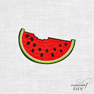 Könnte beinhalten: Ein gestickter Aufnäher in Form eines Wassermelonenstücks mit einem herausgebissenen Stück an der Oberseite. Der Aufnäher zeigt ein leuchtend rotes Fruchtfleisch mit schwarzen gestickten Kernen, einer dünnen weißen Schale und einem grünen Rand.