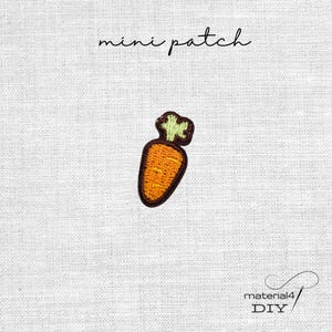 Könnte beinhalten: Ein gestickter Mini-Aufnäher in Form einer Karotte mit orangefarbenem Körper, hellgrünem Blattwerk und dunkelbraunem Rand. Der Text "mini patch" steht über der Karotte und "material4 DIY" ist in der unteren rechten Ecke aufgedruckt.