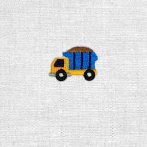 Könnte beinhalten: Gestickter Aufnäher eines gelb-blauen Muldenkippers mit brauner Ladung. Der LKW hat schwarze Räder und ein schwarzes Fenster. Der Aufnäher befindet sich auf einem weißen Stoffhintergrund.