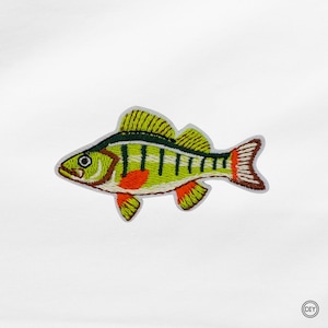 Könnte beinhalten: Gestickter Aufnäher eines Fisches in Gelb, Grün und Orange. Das Design zeigt detaillierte Streifen und Flossen. Geeignet für Kleidung oder Accessoires.
