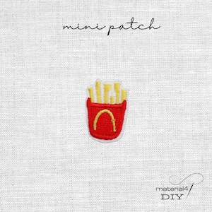 Könnte beinhalten: Ein kleiner gestickter Aufnäher mit einem roten Behälter, der mit gelben Pommes frites gefüllt ist. Der Text 'mini patch' steht über dem Design und der Text 'material4 DIY' befindet sich in der unteren rechten Ecke des Bildes.