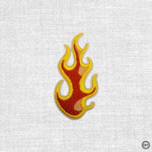 Könnte beinhalten: Gestickter Aufnäher in Form einer Flamme. Die Flamme ist hauptsächlich rot mit gelben und beigen Akzenten, umrandet von Gelb. Geeignet für Kleidung oder Accessoires.