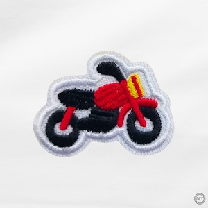 Könnte beinhalten: Gestickter Aufnäher mit einem Motorrad-Design. Der Aufnäher hat einen schwarzen Körper, rote Akzente und einen gelben Streifen. Das Motorrad ist weiß umrandet und hat schwarze Reifen. Der Aufnäher befindet sich auf weißem Hintergrund.