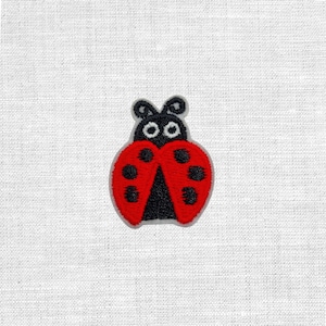 Könnte beinhalten: Gestickter Marienkäfer-Aufnäher mit rotem Körper und schwarzen Punkten, einem schwarzen Kopf und einer grauen Umrandung. Der Aufnäher ist zum Aufnähen oder Aufbügeln auf Stoff konzipiert.