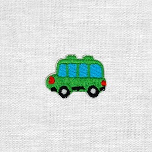 Könnte beinhalten: Ein gestickter Aufnäher in Form eines Busses mit einem leuchtend grünen Körper, vier blauen rechteckigen Fenstern, schwarzen Rädern mit weißen Zentren sowie kleinen roten runden Lichtern an der Vorder- und Rückseite des Fahrzeugs.