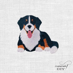 Könnte beinhalten: Ein gestickter Aufnäher, der einen Berner Sennenhund mit schwarzem, weißem und braunem Fell zeigt. Der Hund ist in liegender Position mit herausgestreckter Zunge dargestellt und weist detaillierte Stickereien in Schwarz, Weiß, Braun und Rosa auf.