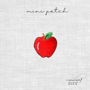 Könnte beinhalten: Ein kleiner gestickter Apfel-Aufnäher mit einer leuchtend roten Frucht, einem braunen Stiel und einem grünen Blatt. Der Text 'mini patch' steht über dem Apfel und der Text 'material4 DIY' befindet sich in der unteren rechten Ecke.