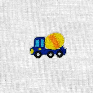 Könnte beinhalten: Gestickter Aufnäher eines blauen Betonmischers mit einem gelb-orangen Betonmischer. Der LKW hat schwarze Räder, einen gelben Scheinwerfer und blaue Fenster. Der Aufnäher befindet sich auf einem weißen Stoffhintergrund.