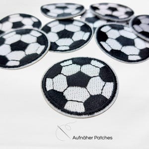 Könnte beinhalten: Eine Ansammlung von schwarz-weißen Fußball-Patches. Die runden Patches zeigen ein detailliertes Design aus Fünf- und Sechsecken. Der Text "Aufnäher Patches" ist unten rechts sichtbar.