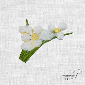Könnte beinhalten: Gestickte weiße Blumen mit gelben Zentren und grünen Stielen auf weißem Stoffhintergrund. Die Stickerei weist detaillierte Stiche auf, die ein strukturiertes Aussehen erzeugen. Das Bild enthält den Text "material4 DIY".