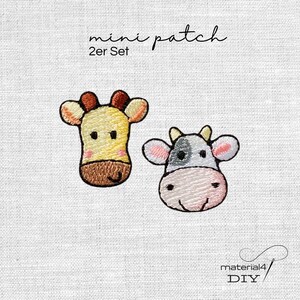 Könnte beinhalten: Ein Set aus zwei gestickten Mini-Aufnähern mit einem gelben Giraffenkopf und einem weiß-grauen Kuhkopf. Der Text mini patch 2er Set ist oben zu sehen, und der Text material4 DIY befindet sich in der unteren rechten Ecke.