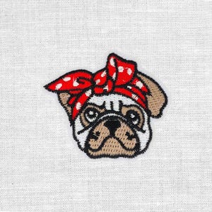 Könnte beinhalten: Gestickter Aufnäher mit einer Möpschen, das ein rotes Bandana mit weißen Punkten trägt. Das Gesicht des Mops ist mit braunem, schwarzem und weißem Garn detailliert, das seine Falten und seinen Ausdruck zeigt. Der Aufnäher hat einen schwarzen Rand.