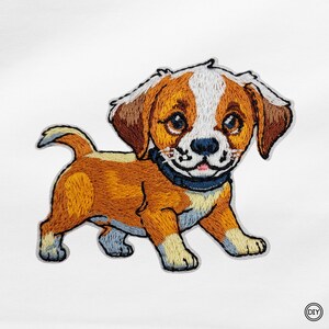 Könnte beinhalten: Gestickter Aufnäher mit einem Cartoon-Welpen mit braunem, weißem und hellbraunem Fell. Der Hund hat ein schwarzes Halsband und lächelt. Der Aufnäher befindet sich auf weißem Hintergrund und eignet sich für DIY-Projekte.