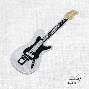 Könnte beinhalten: Ein gestickter Aufbügler in Form einer E-Gitarre. Der Gitarrenkörper ist weiß mit einem schwarzen Zentrum, ergänzt durch schwarz-weiße Griffbrettdetails und einen goldfarbenen Kopf. Das Design ist in dichter Stickerei ausgeführt.
