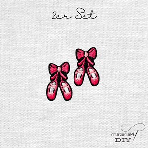 Könnte beinhalten: Ein Set aus zwei gestickten Aufnähern, die Ballettschuhe in Rosa- und Schwarztönen mit Schleifendetails zeigen. Der Text 2er Set steht über den Aufnähern und der Text material4 DIY befindet sich in der unteren rechten Ecke.