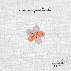 Könnte beinhalten: Ein Mini-Aufnäher mit einer gestickten Blume mit fünf Blütenblättern in abwechselnden Farbtönen von Hellrosa und Pfirsich, zentriert mit einem gelben Staubgefäß. Der Text mini patch steht darüber, material4 DIY darunter.