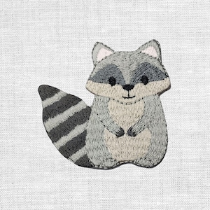 Könnte beinhalten: Eine weiße Keramik-Tasse mit schwarzem Henkel und dem Text "But First, Coffee" in schwarzer, handschriftlicher Schrift. Die Tasse steht auf einer weißen Oberfläche.