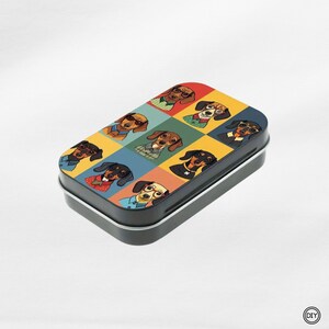 Könnte beinhalten: Eine rechteckige schwarze Blechdose mit einem farbenfrohen Dackel-Design. Die Oberseite zeigt ein Raster von Dackel-Illustrationen, die Brillen und verschiedene Outfits tragen, vor dem Hintergrund verschiedenfarbiger Quadrate. Die Dose wird wahrscheinlich zur Aufbewahrung verwendet.