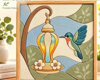 Puede incluir: Una pieza de arte en tela Kinusaiga cuadrada en un marco de madera clara que muestra un colibrí acercándose a un comedero colgante. El diseño utiliza paneles de tela texturizada en tonos azul, verde, amarillo y naranja, con detalles florales blancos.
