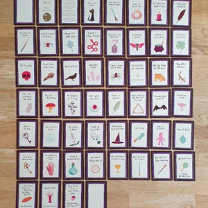 May include: A set of 48 tarot cards with colorful illustrations and text on each card. The cards are arranged in a grid pattern on a wooden surface. The cards feature a variety of images, including animals, plants, and objects. The text on the cards is in a handwritten style.