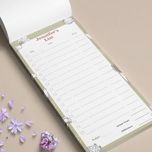 May include: A rectangular notepad with a sage green border featuring line drawings of vegetables. The header reads Jennifer's List, with columns for Qty, Item, and Price. The bottom includes fields for Budget, Grand Total, and Difference.